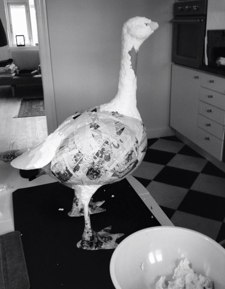 a duck that is standing on a counter next to a bowl with food in it