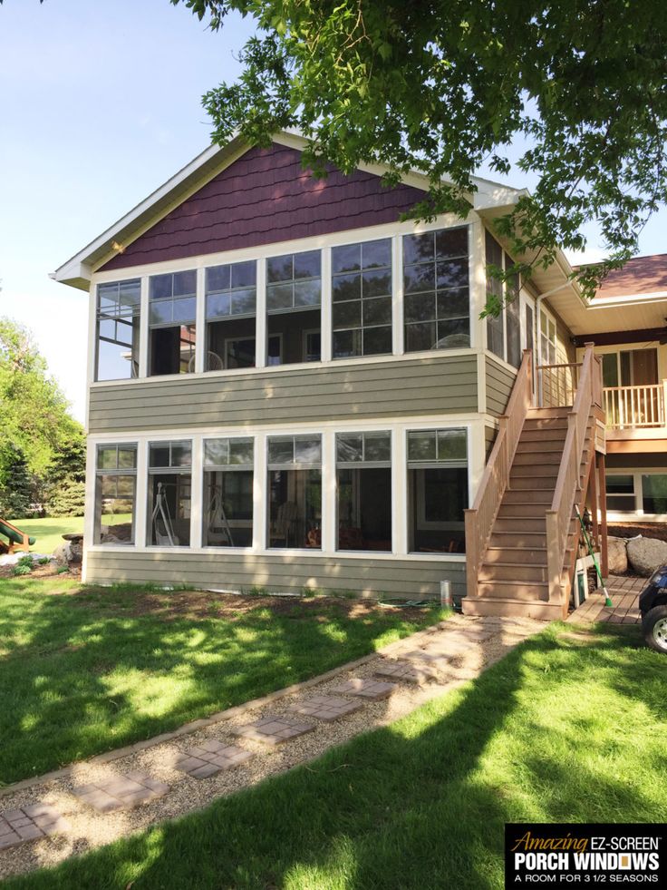 a house with large windows and stairs leading up to the second story, on a sunny day