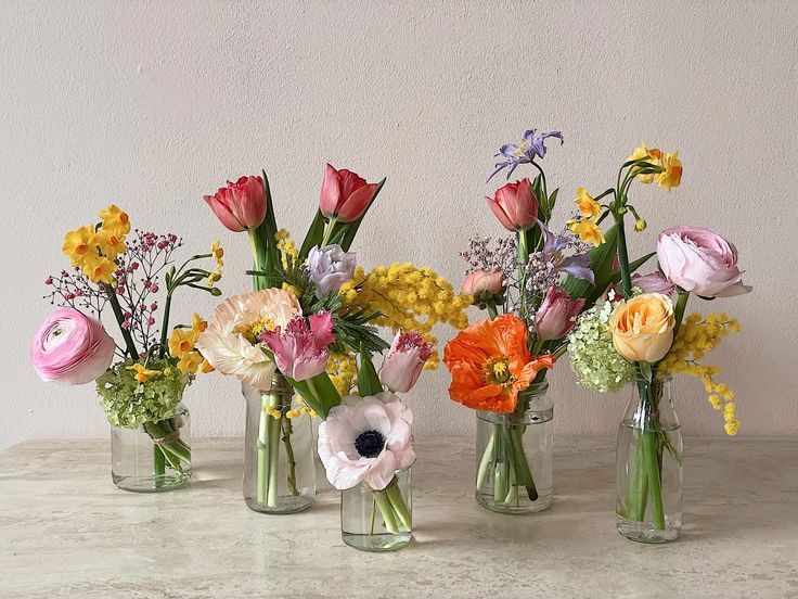 four vases filled with different types of flowers