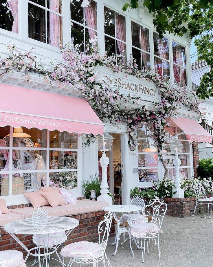 an outdoor cafe with pink and white decor