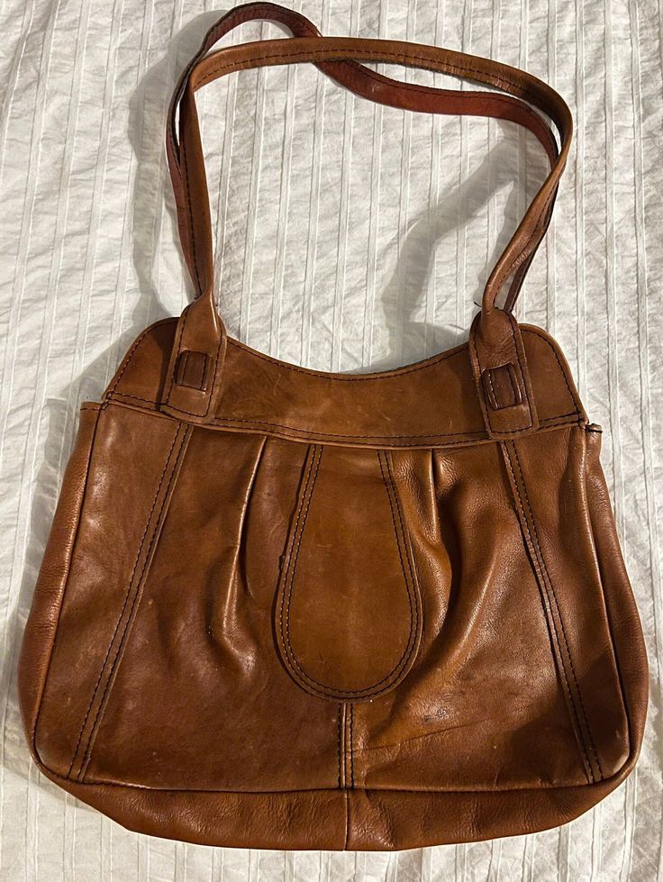 Vintage brown leather saddle bag-shaped purse. Measurements in photos. Could use some good leather conditioning. Sourced from a flea market where most items are from 1950s-90s. The inside is not lined, and various wear on the bag is pictured. Vintage Brown Leather Shoulder Bag, Leather Saddle Bags, Brown Leather Shoulder Bag, Saddle Bag, Nice Leather, Vintage Brown, Flea Market, Saddle Bags, Purses And Handbags