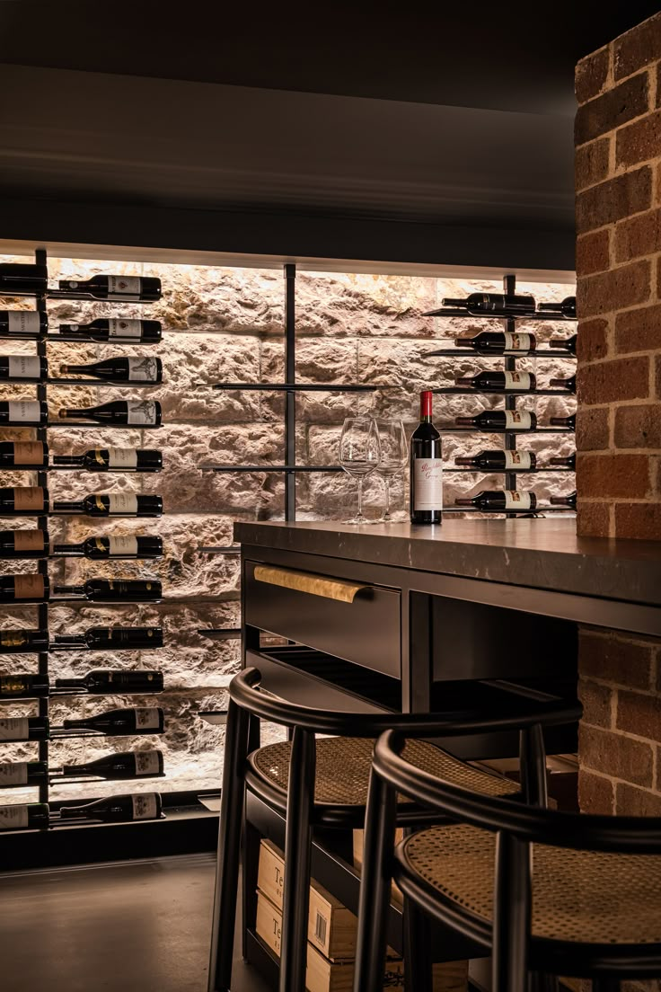 the wine bottles are lined up on the bar in front of the brick wall and windows