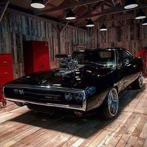 an old muscle car parked in a garage