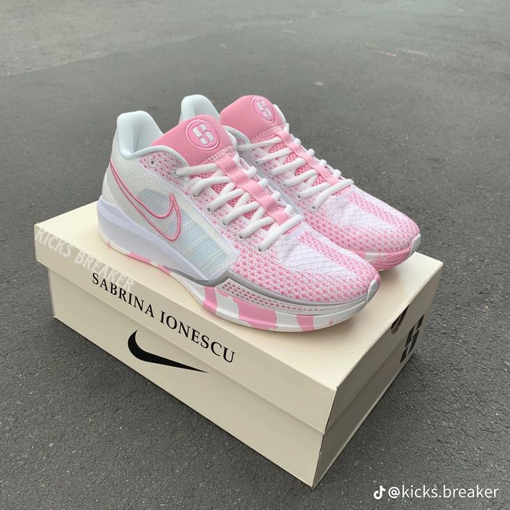 a pair of pink and white nike shoes on top of a box with the words sarina ionescu printed on it