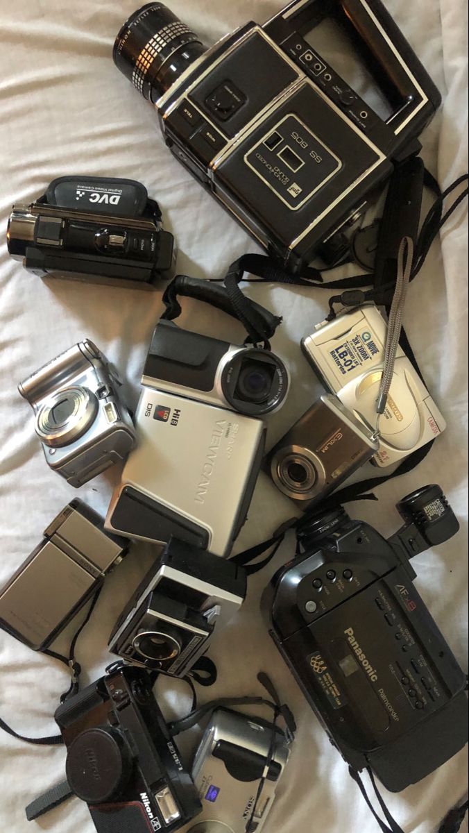 many different types of cameras on a bed