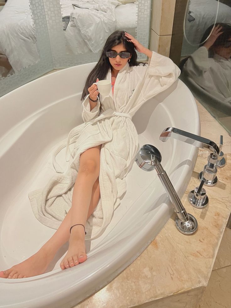 a woman sitting in a bathtub with her feet up