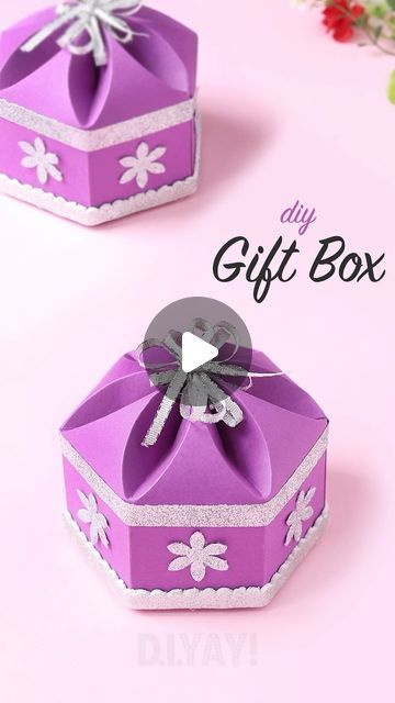 two purple gift boxes with bows on them