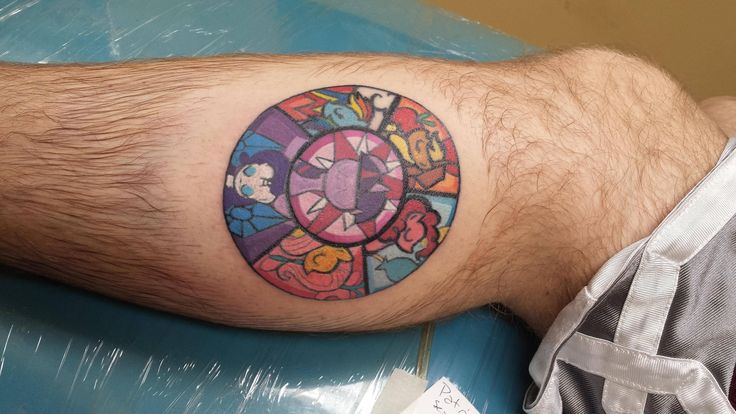 a man's leg with a tattoo on it that has an image of mickey mouse in the center