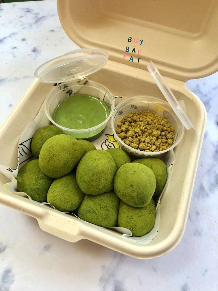 there are some green food in the container on the table with it's lid open