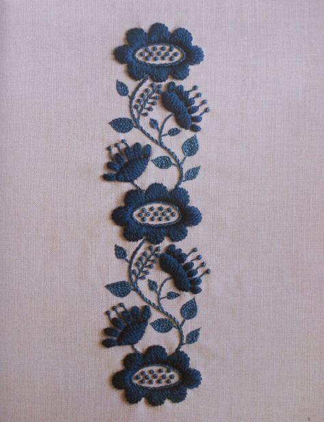 an embroidered piece of cloth with blue flowers on it