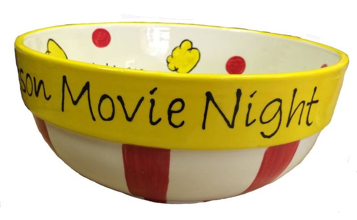 a yellow and red striped bowl with popcorn movie night written on the side in black ink