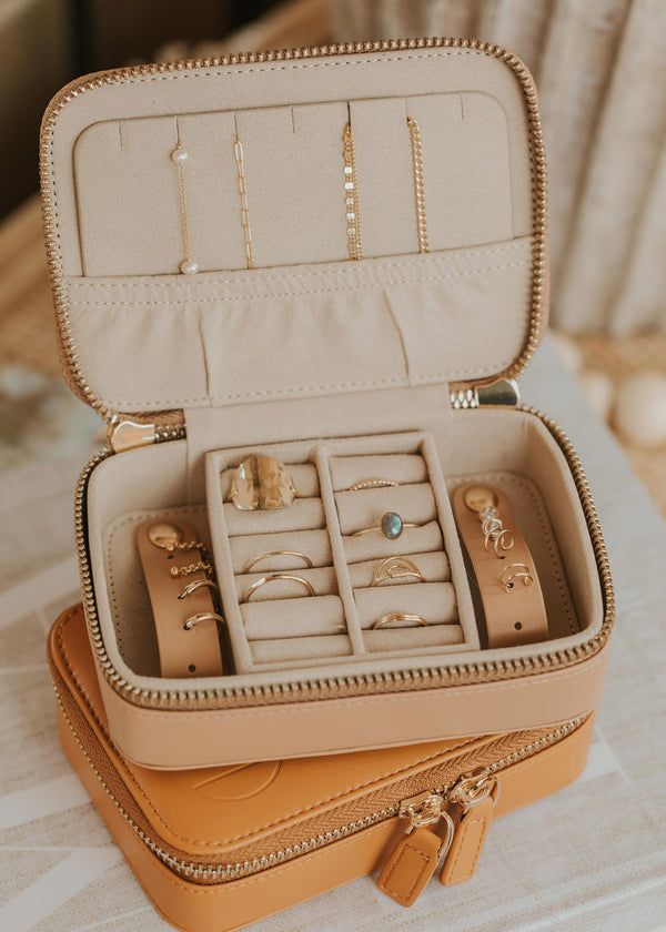 an open suitcase filled with jewelry on top of a table