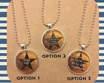 three necklaces with words on them sitting next to each other