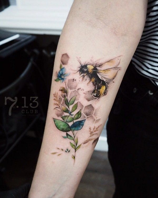 a woman's arm with a bee and flowers on it