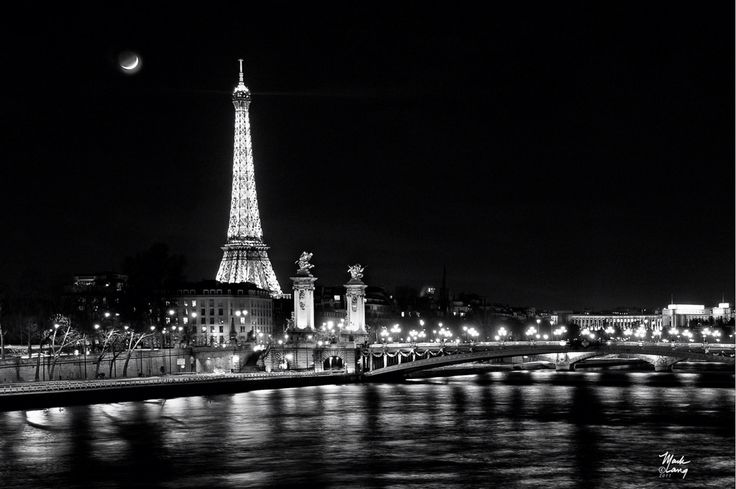 the eiffel tower is lit up in black and white at night with lights on