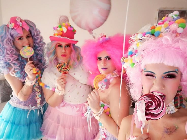 three women dressed up as candy land characters eating lollipops and holding lollipop sticks