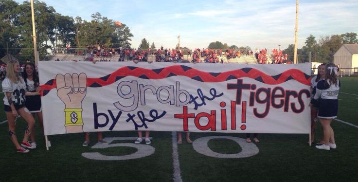 some girls are holding up a banner on the field