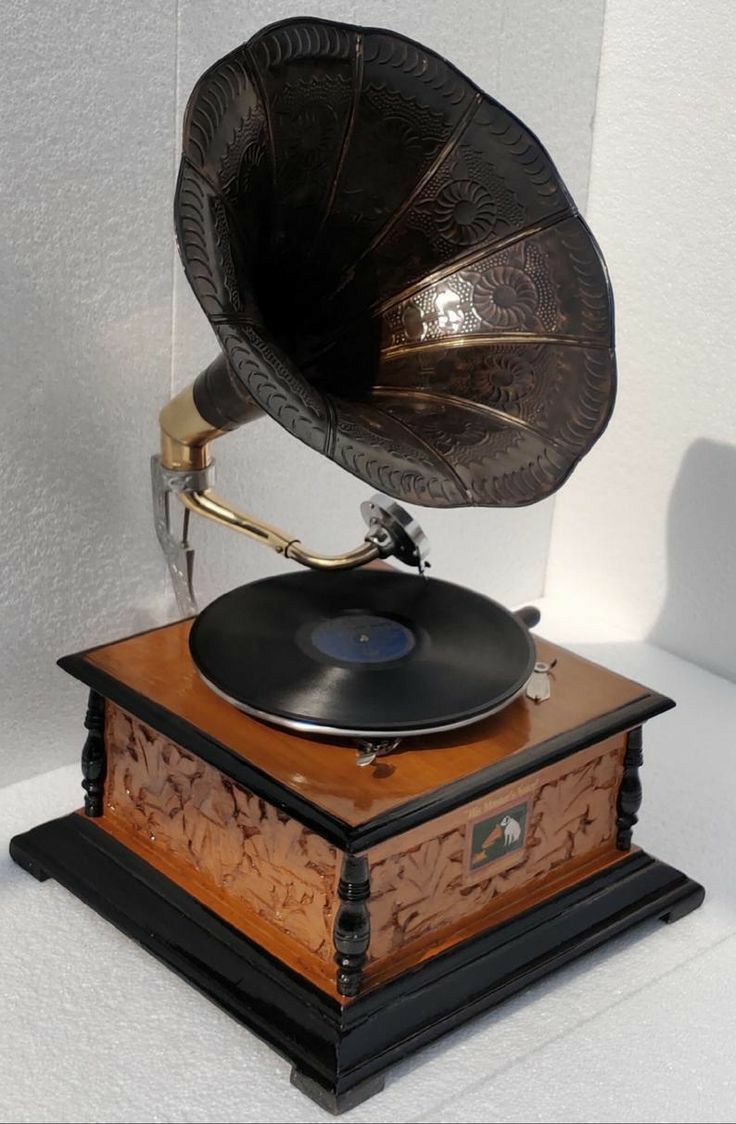 an old fashioned record player sitting on top of a wooden box with a brass horn