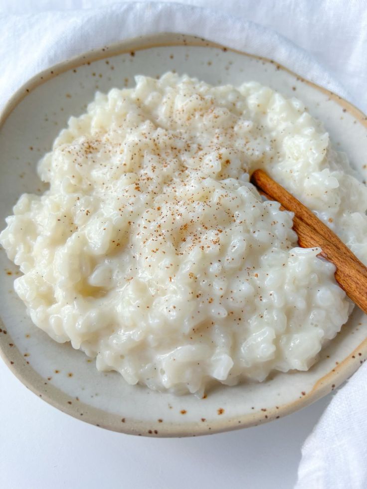 a bowl filled with mashed potatoes and cinnamon on top of a white table cloth