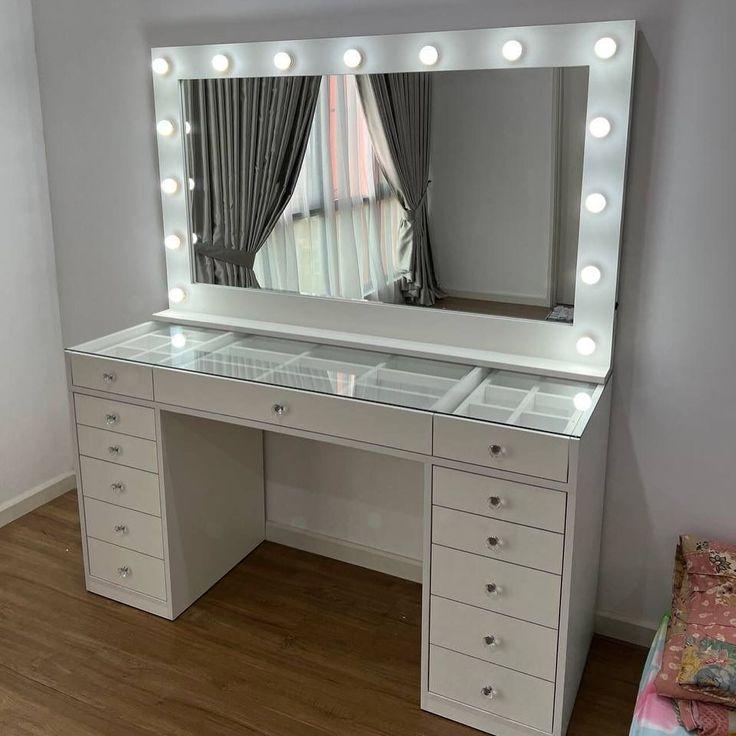 a white vanity with lights on it and a mirror in front of the counter top