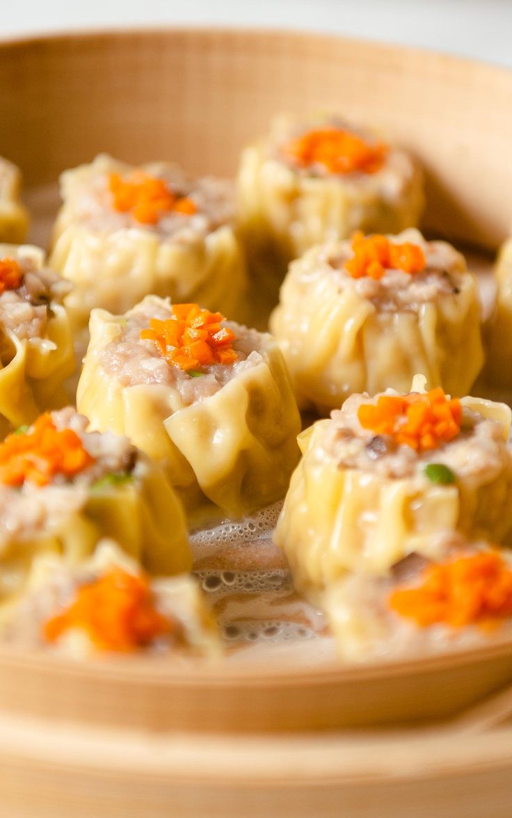 some dumplings with carrots are in a wooden bowl