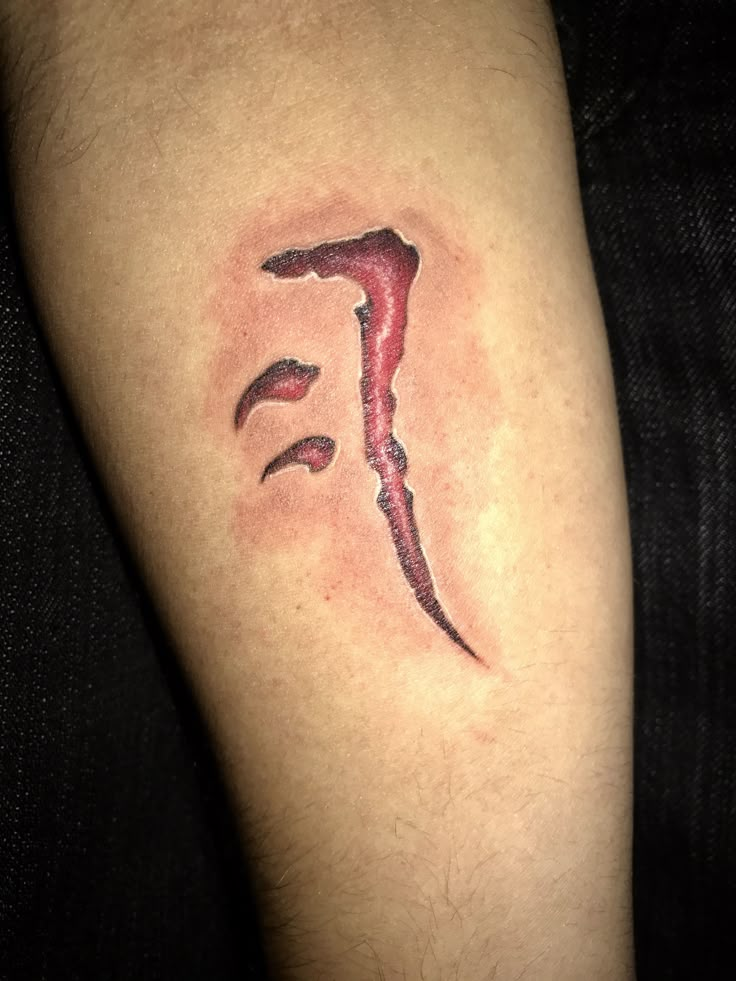 a man with a tattoo on his leg that has the letter f painted on it