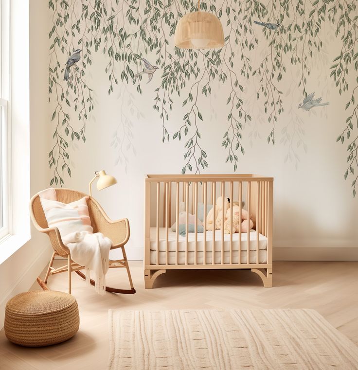 a baby's room with a crib, rocking chair and tree mural on the wall