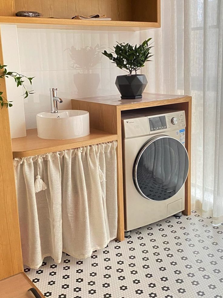 a washer and dryer in a small room next to a window with curtains