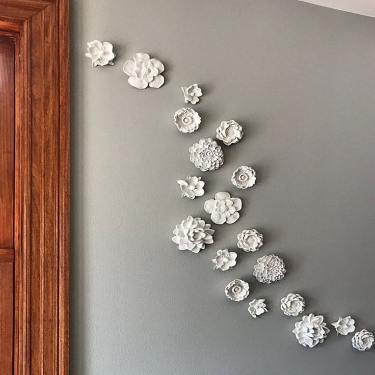 the wall is decorated with white paper flowers