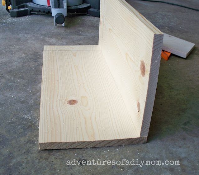 a wooden bench sitting on top of a floor next to a sawing board and tools