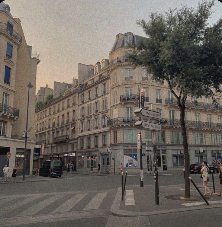 people are walking on the street in front of some buildings