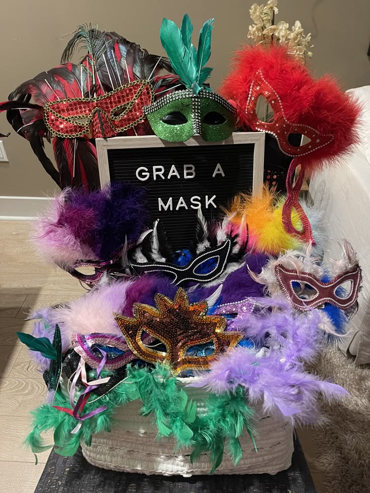 a group of masquerades sitting on top of a table next to a sign that says grab a mask