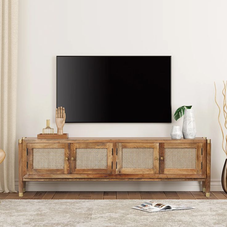 a flat screen tv mounted to the side of a wooden cabinet in a living room