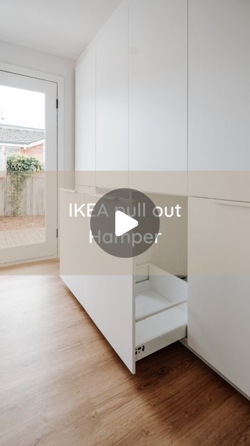 an empty room with wooden floors and white cabinets