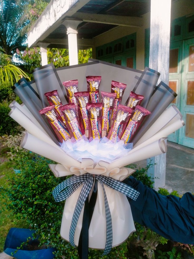 a bunch of candy bars wrapped in white paper and tied to a ribbon on the front of a house