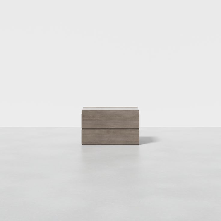 a small wooden box sitting on top of a white floor in front of a wall