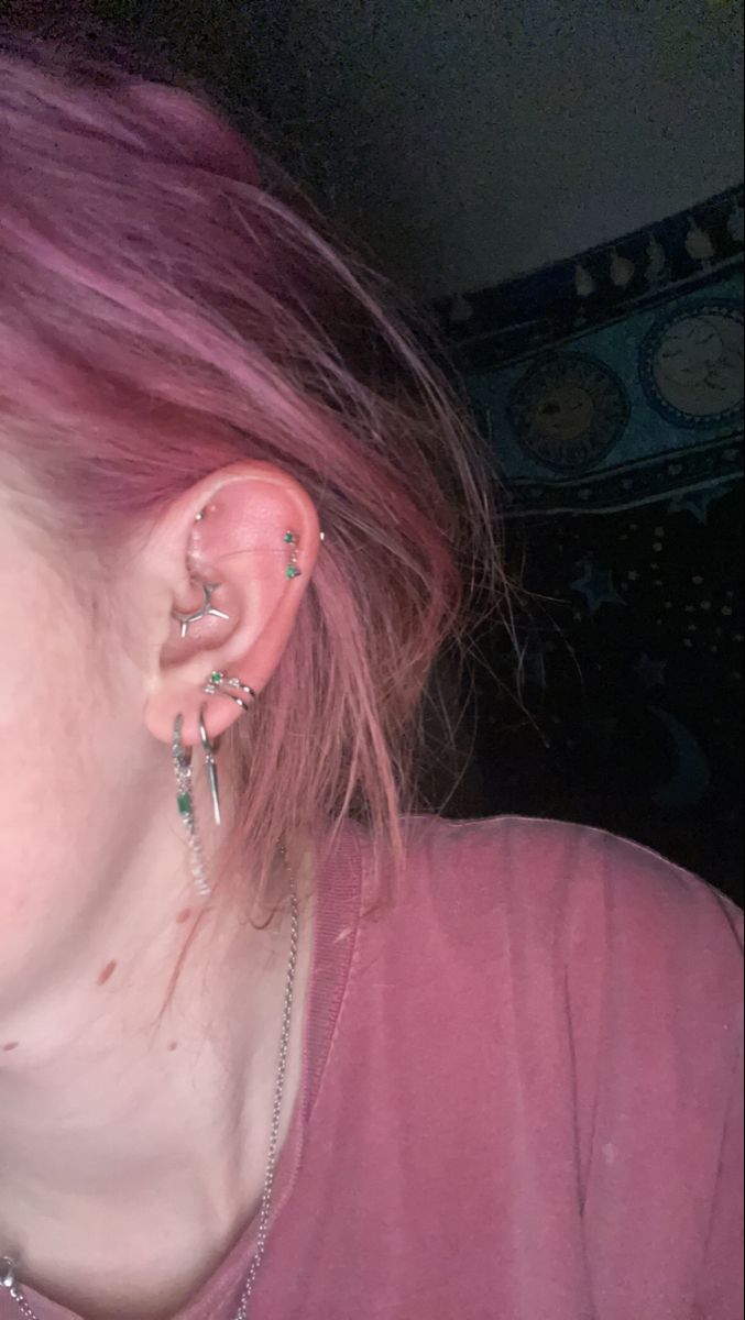 a woman with pink hair and piercings on her ear