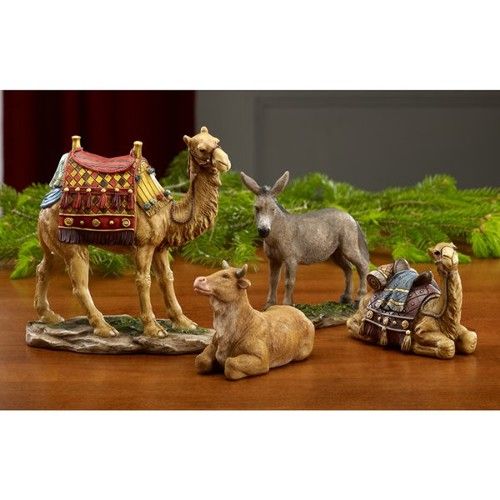 three figurines of camels and donkeys on a table