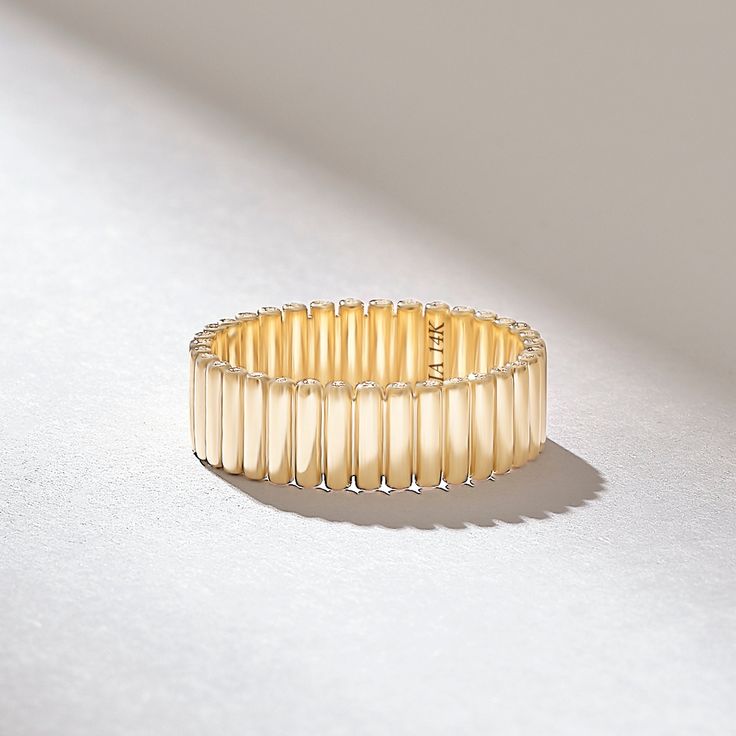 a close up of a bracelet on a white surface with light shining through the middle