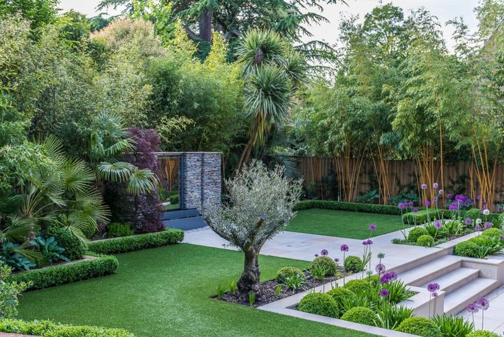 an outdoor garden with grass, trees and steps leading up to the top of it