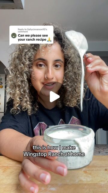 a woman with curly hair is holding a spoon in front of her face