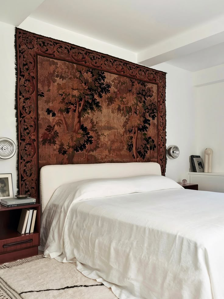 a bed with a large tapestry on the headboard