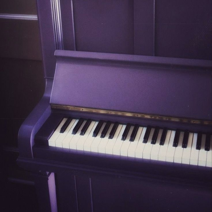 a purple piano sitting in front of a wall