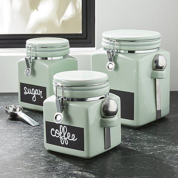 three mint green coffee canisters sitting on a counter next to a spoon and cup