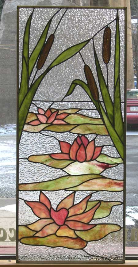 a stained glass window with water lilies and reeds