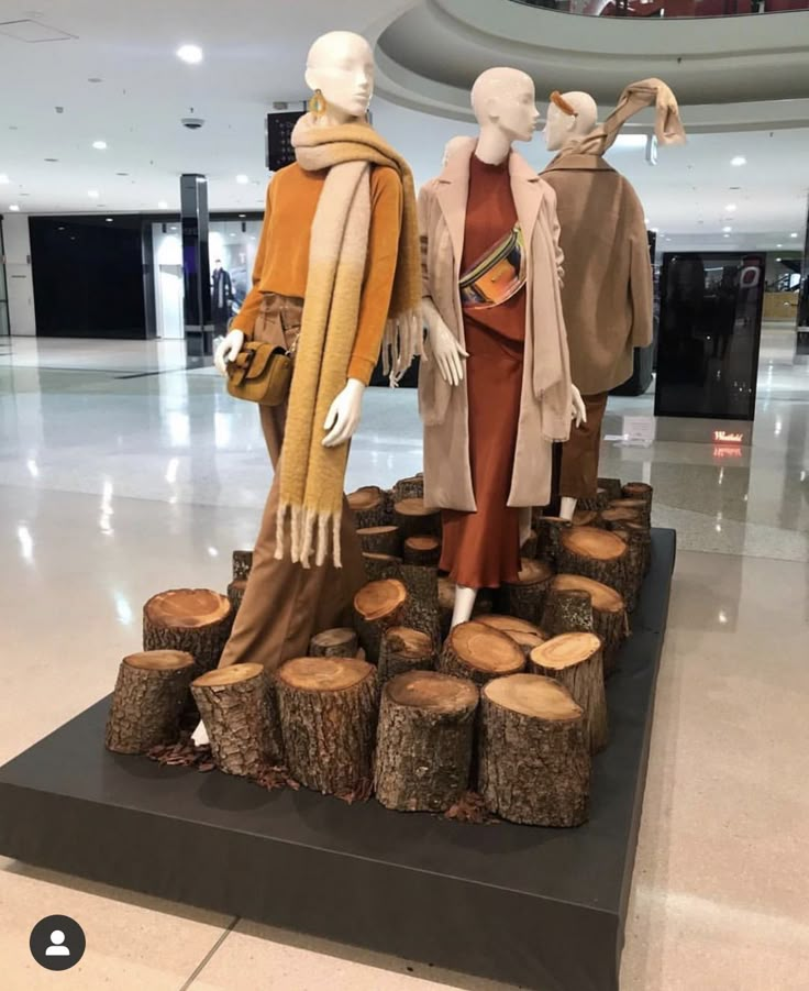 two mannequins are standing on logs in the lobby