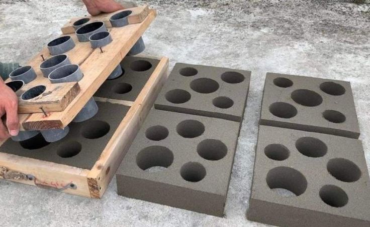 a man is making cup holders out of cinder blocks