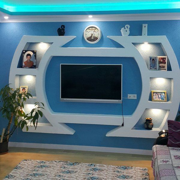 a living room with blue walls and white shelves