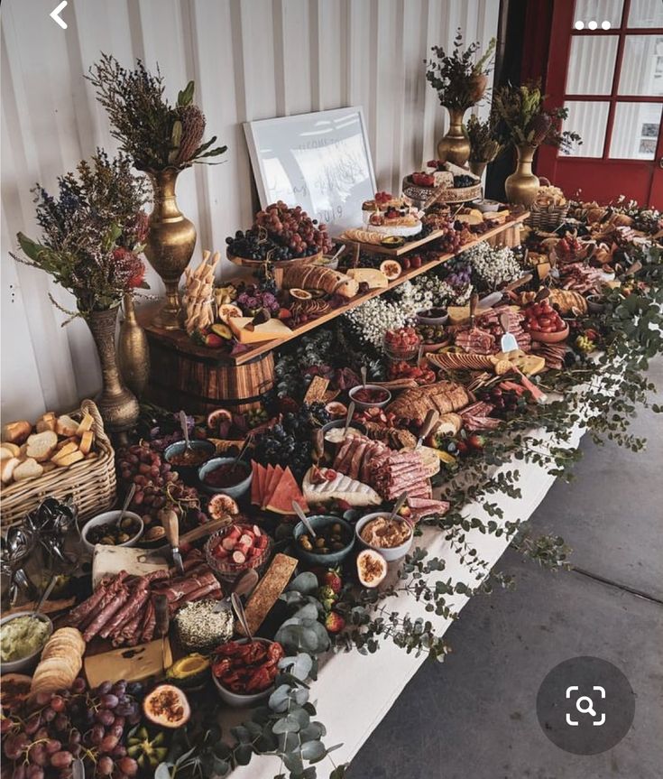 a table filled with lots of food next to a red door