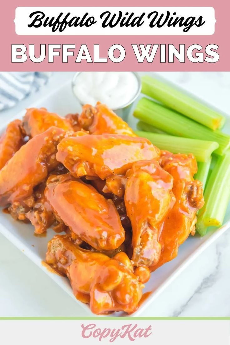 buffalo wings on a white plate with celery and green beans in the background